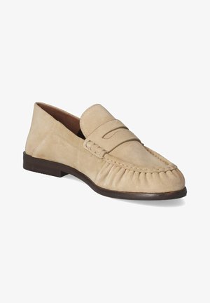 Mocassin penny loafer en daim beige avec bout moc cousu, talon bas marron foncé et bride décorative sur le cou-de-pied.