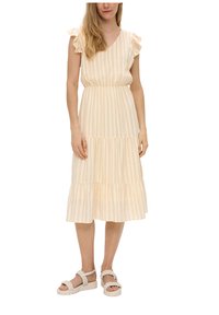 Leicht gestreiftes gelbes Midikleid mit tailliertem Schnitt, Rüschensäumen, gestuftem Rock und kombiniert mit geflochtenen weißen Sandalen.