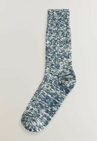 Minkštas tamsiai mėlynas ir baltas, dėmėtas raštas, iki vidurio blauzdos ilgio megztas dėklas, su sustiprinta kulno dalimi ir be siūlių kojų dalimi patogumui.
