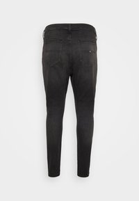 Fekete farmer skinny nadrág sima textúrával, két hátsó zsebbel és kiemelt varrással. A derékpánton övhurkok találhatók.