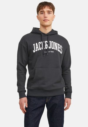 Dunkelgrauer Hoodie mit weißem "JACK & JONES"-Text, Kängurutasche, verstellbarem Kordelzug, gerippten Bündchen und Saum; kombiniert mit dunkelblauen Jeans.