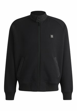 Black zip-up jacket with a stand collar, ribbed cuffs, and side pockets. Features quilted detailing on pocket edges and a branded logo.