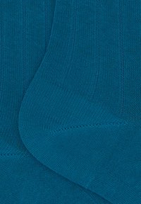 Calze a coste color teal realizzate in morbido materiale knit, con motivi alternati a rilievo e piatti, dotate di una cucitura della punta liscia e di un polsino elastico.