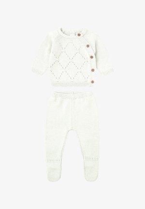 Conjunto de bebé de punto color crema con cárdigan de manga larga, botones laterales y patrón de rombos, combinado con pantalones con pies a juego.