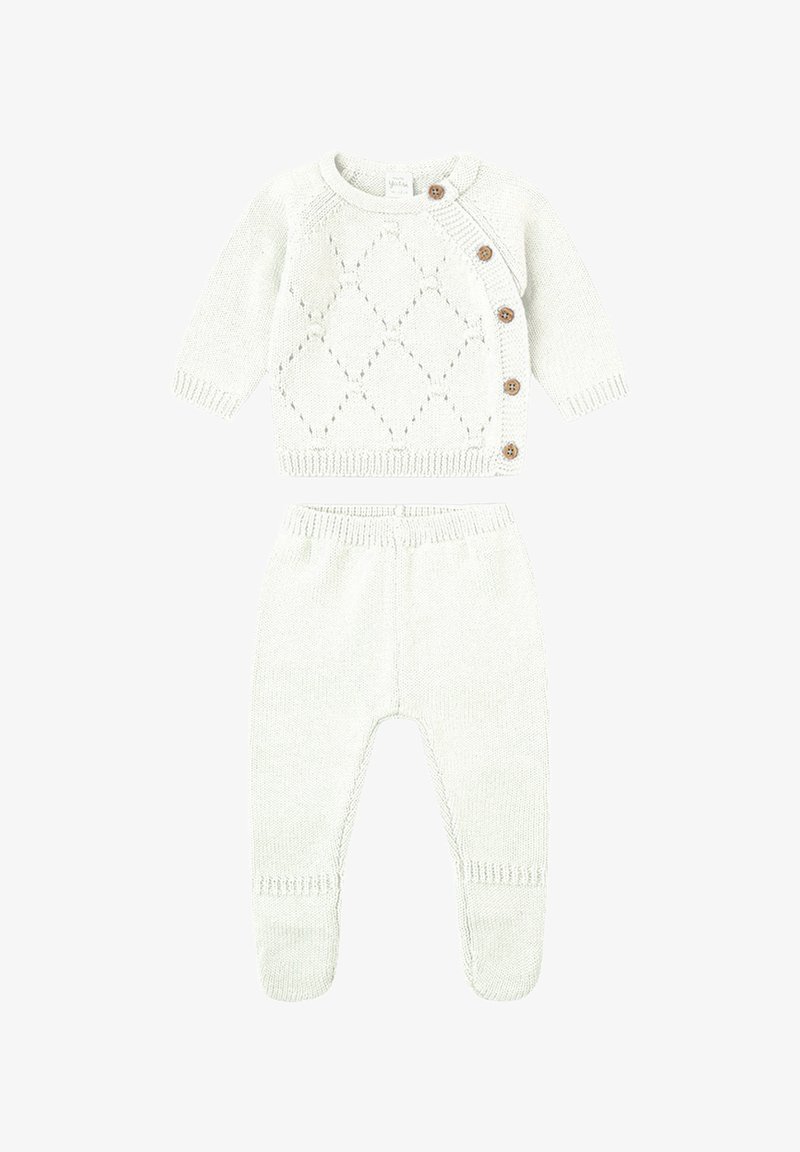 Conjunto de bebé de punto color crema con cárdigan de manga larga, botones laterales y patrón de rombos, combinado con pantalones con pies a juego.