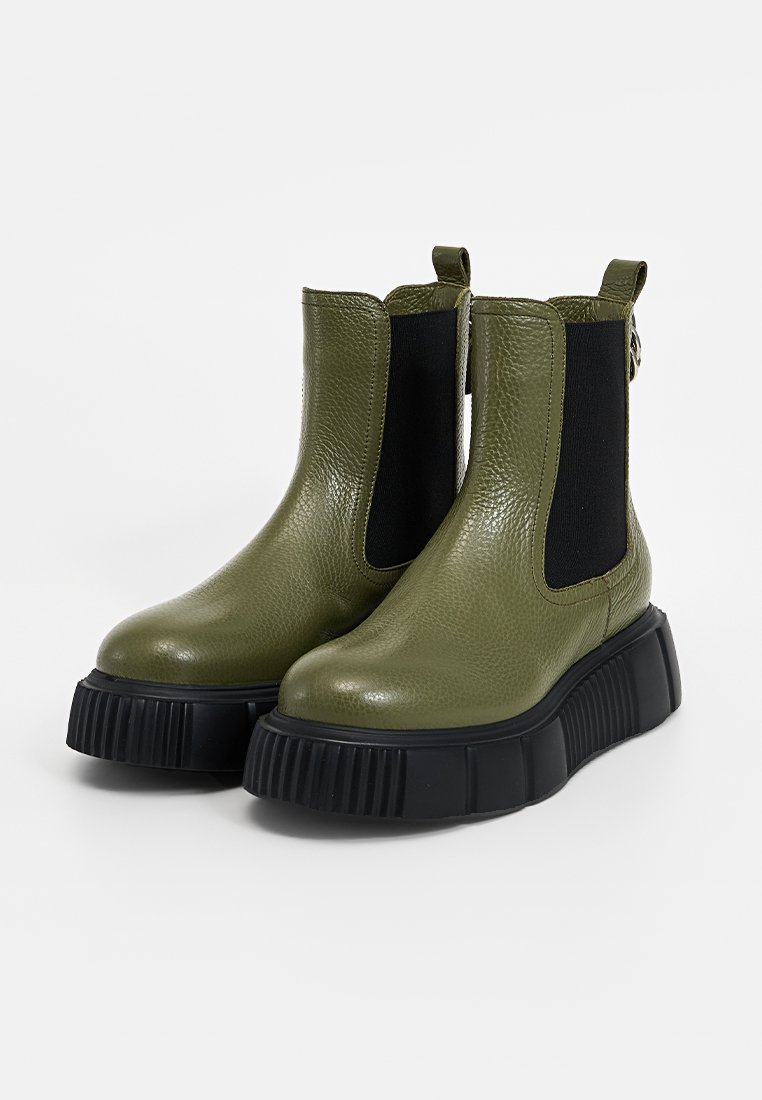 Zielone skórzane botki na kostkę z elastycznymi czarnymi panelami bocznymi i masywną czarną gumową podeszwą. Teksturowane wykończenie dodaje szczegółów do designu.
