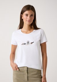 Weißes Baumwoll-T-Shirt mit einem grafischen Druck von Schminkutensilien und dem Text "einfach glamourös". Kurze Ärmel und runder Ausschnitt.