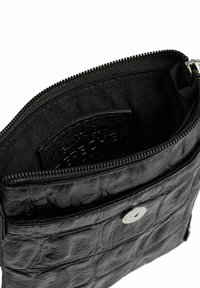 Portafoglio nero con zip, dalla texture effetto coccodrillo, con accessori in argento e interno in tessuto. Presenta uno slot per carte e un compartimento spazioso.