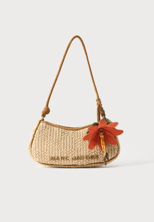 Gewebte beige Marc Jacobs Schultertasche mit geknotetem Träger und orangefarbenem Blumenanhänger auf der rechten Seite vor einfachem Hintergrund.