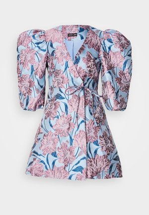 Bloemenzwemjurk met grote pofmouwen, een lichtblauwe achtergrond met roze en blauwe bloemenpatronen, en een strikceintuur in de taille.