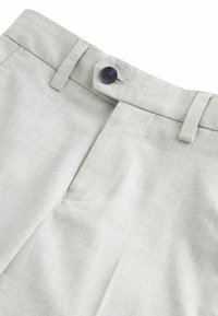 Pantalones de lino gris claro con frente plano, cierre de botón único y textura sutil. Presenta una cinturilla lisa y líneas limpias.