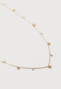 Λεπτό χρυσό κολιέ με εναλλασσόμενες μικρές μαργαριτάρια και στρογγυλά κρύσταλλα σε λευκό φόντο.