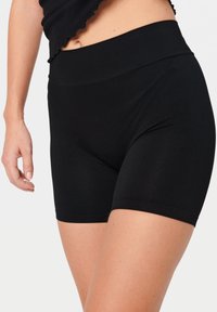 Zwarte high-waisted shorts van rekbaar materiaal, met een gladde textuur en een aansluitend ontwerp, eindigend halverwege de dij.