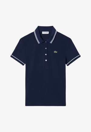 Polo de manga corta azul marino con doble rayas blancas en el cuello y los bordes de las mangas, tapeta de cuatro botones y logo de cocodrilo verde en el pecho.
