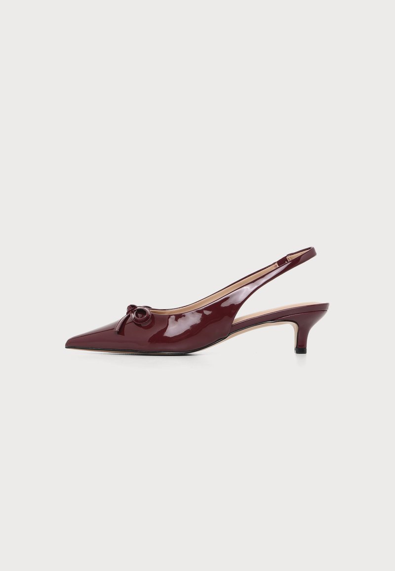Μπορντό δερμάτινο slingback από γυαλιστερό δέρμα με μυτερή μύτη, μικρό τακούνι και διακοσμητικό φιόγκο στο πάνω μέρος σε λευκό φόντο.