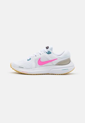 White athletic shoe with a textured upper, pink Nike swoosh, and light blue accents. Features a cushioned sole and rubber outsole for traction.