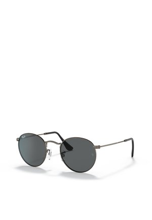 Occhiali da sole rotondi con lenti scure, montatura metallica sottile e cuscinetti nasali in gomma. Le astine passano dal colore argento al nero. Design minimalista.