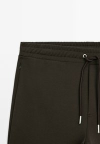 Dunkelbrown Sweatpants mit elastischem Bund, Zugbandschmuck und seitlichen Taschen. Glatte Stoffstruktur mit lässigem Design.