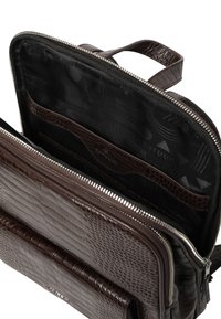 Brązowa, teksturowana skórzana torba z zamkiem błyskawicznym, z czarnym wnętrzem, kieszeniami do organizacji oraz kontrastową podszewką z tkaniny.