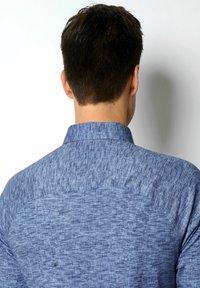 Blaue Hemd mit strukturiertem Gewebe, ausgestattet mit einem klassischen Kragen und Schulterpasse. Der Stoff wirkt leicht und lässig im Stil.