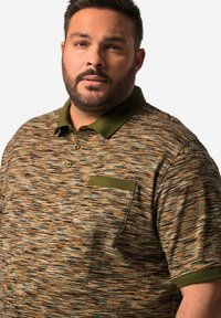 Stickad polo-shirt i jordnära färger, med ett texturerat mönster, grön krage och en liten bröstficka med matchande kant.
