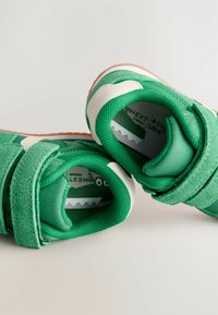 Zielone sneakersy z mieszanką teksturowanej tkaniny i zamszu, z białymi akcentami i paskiem na rzep, z wyściełanym kołnierzem.