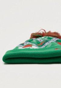 Caciulă tricotată verde cu modele roșii și albe și un pompon roșu în vârf. Materialul pare moale și texturat.