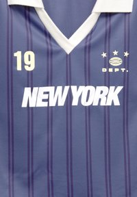 Blå og lilla stribet sportsjersey med hvid krave, nummer 19, teksten "NEW YORK" og et globuslogo med tre stjerner og "DEPT."