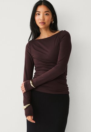 Langsleeve shirt in diep bordeaux, gemaakt van zachte stof. Heeft een bootnecklijn en een strakke pasvorm, met verlengde manchetten. Eenvoudig, elegant ontwerp.