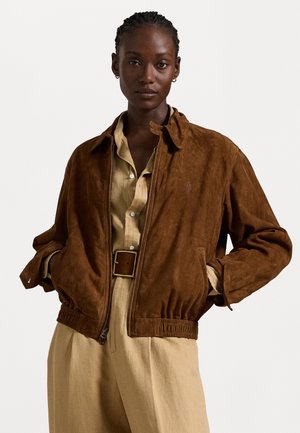 Brown suede bomber jacket with a collared neckline, elasticized hem, and zip closure; features side pockets and a subtle logo detail.
