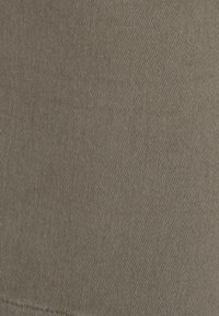 Tessuto di cotone marrone con una trama diagonale texturizzata, caratterizzato da un colore uniforme e una superficie liscia, ideale per capi d'abbigliamento casual.