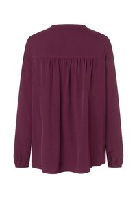 Burgundy long-sleeve blouse with a round neckline, gathered back detail, and elastic cuffs. Soft fabric with a smooth texture.