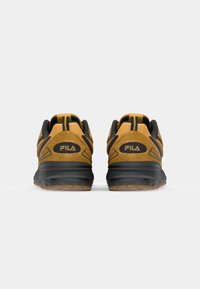 Brown suede athletic shoes with black accents, featuring a padded collar, cushioned sole, and prominent logo on the heel.