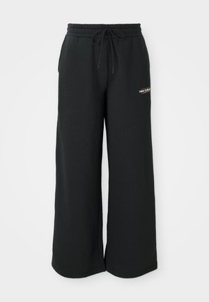 Pantalons de survêtement larges noirs en tissu doux, dotés d'une taille élastique avec cordon de serrage et d'un petit logo sur le côté gauche.