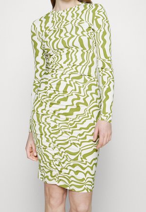 Sukienka z długim rękawem wykonana z elastycznej tkaniny, zdobiona zielonym i białym falistym wzorem. Marszczenia po bokach dodają tekstury i podkreślają kształt.