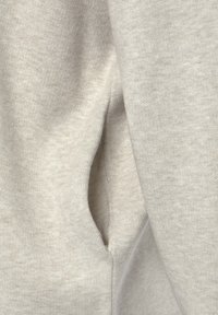 Helles graues Baumwoll-Sweatshirt mit einer weichen Textur, ausgestattet mit einer seitlichen Eingrifftasche und einem schlichten, minimalistischem Design.