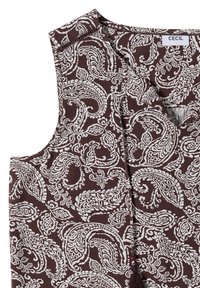 Haut marron sans manches avec des motifs blancs complexes de paisley et floraux et un détail de pompon près de l'encolure.