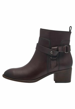Bottine en cuir marron avec un bout arrondi, un détail de sangle ceinturée et un talon carré texturé. Fini lisse, construction robuste.
