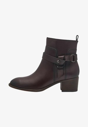 Bottine en cuir marron avec un bout arrondi, un détail de sangle ceinturée et un talon carré texturé. Fini lisse, construction robuste.