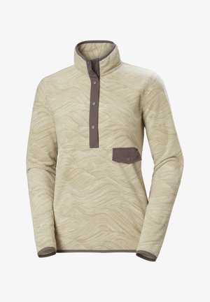 Polarowy pulower w kolorze kremowym z falistym wzorem, kontrastującymi brązowymi akcentami, zapięciem na pół guzika oraz małą kieszonką na piersi. Długie rękawy ze ściągaczami.