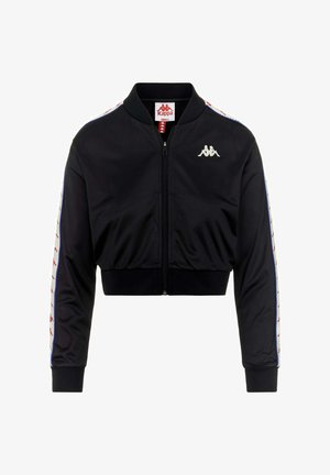 Giacca nera crop in poliestere liscio con zip frontale, polsini a coste e strisce laterali a contrasto con piccoli loghi in rosso e blu.