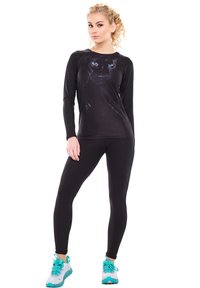 Svart långärmad tröja med en pantergrafik, parat med svarta leggings. Modellen bär turkosa sneakers med svarta accenter och snören.
