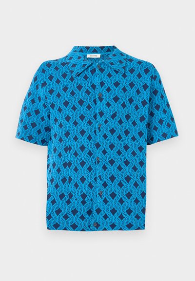 Kortermet skjorte i blått stoff med et geometrisk mønster av sammenflettede linjer, med kragehals og frontknapplukking.