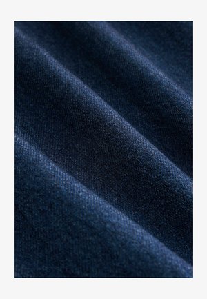 Dark blue denim fabric with a smooth texture featuring diagonal ribbed patterns and subtle variations in color.