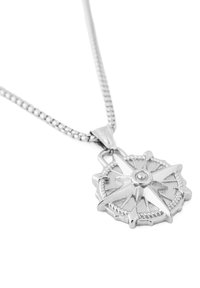 Pendentif en argent en forme de boussole sur une chaîne à motif. Le pendentif présente un design de boussole détaillé et en relief avec un élément circulaire central.