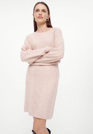 Abito maglione rosa chiaro in design a treccia, con scollatura rotonda e polsini a costine. Silhouette aderente, lunghezza al ginocchio.