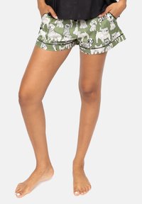 Groene shorts met verschillende dogillustraties in zwart-wit, met een relaxed fit en een subtiele zoomdetail. Lichte stofstructuur.