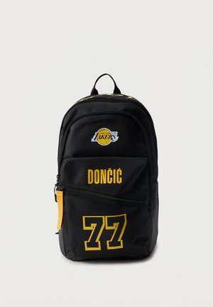 Čierny batoh s logom Los Angeles Lakers, žltým nápisom "DONČIĆ" a číslom 77 v žltej farbe na predných vreckách.