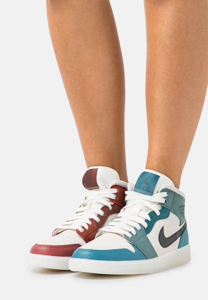 Hoge sneakers met een ontwerp van wit, rood en teal leer, met een getextureerd oppervlak en kenmerkende branding op de tong.