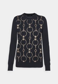 Tmavě modrý svetr s motivem řetězových článků v kovově zlaté barvě. Má žebrovaný výstřih a manžety, dlouhé rukávy a přiléhavý střih.